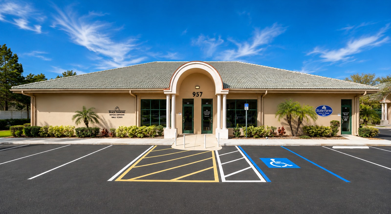957 East Del Webb Boulevard: a single-story tan stucco office building with a barrel-vaulted columned entry, green tile roof and parking directly at the door.